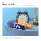 Armbänder in Blau und Gelb neben einem Wecker – das Band weckt nur dich per Vibration